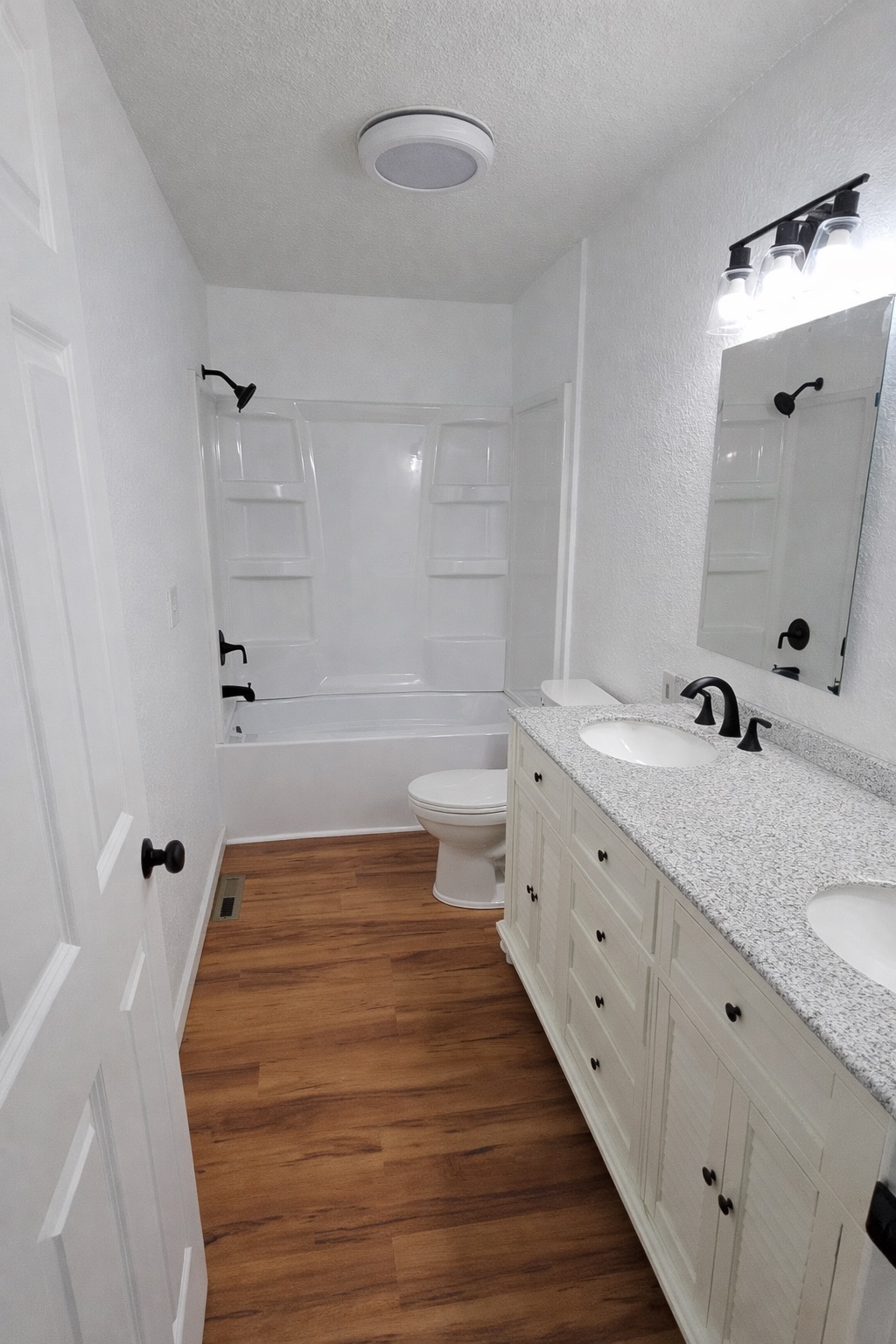 Bathroom remodel with LVP flooring fiberglass tub double vanity and new fixtures in Huntsville Alabama